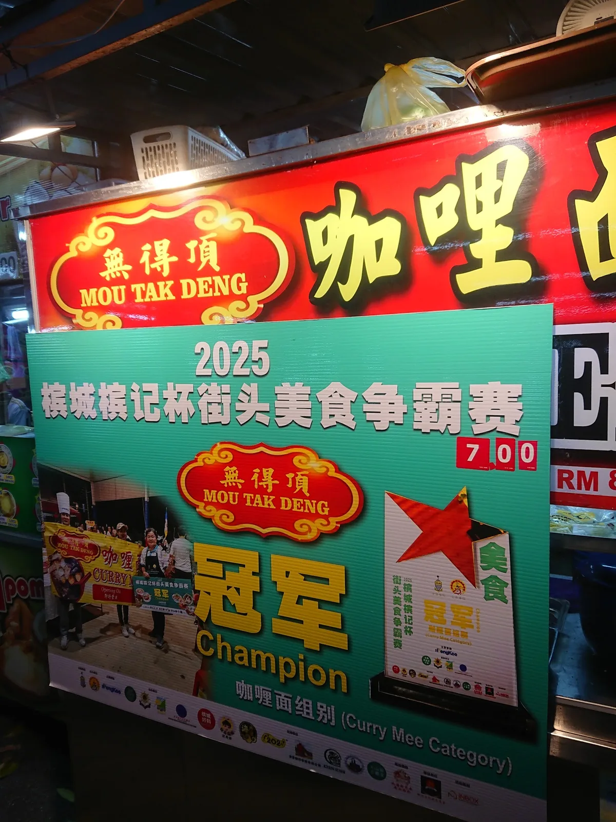 Mou Tak Deng signboard with its 2025 curry mee champion banner
