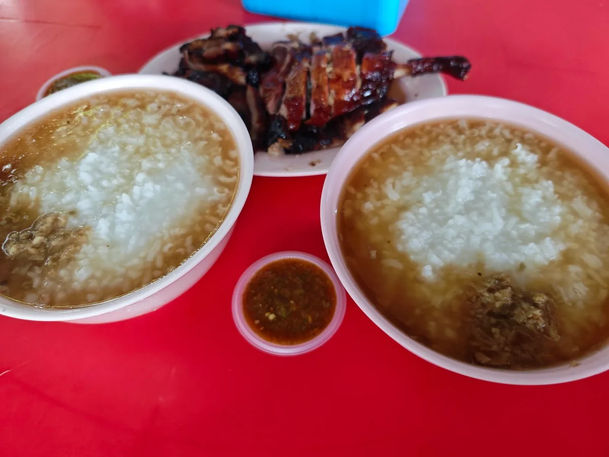 Two bowls of porridge with roast duck