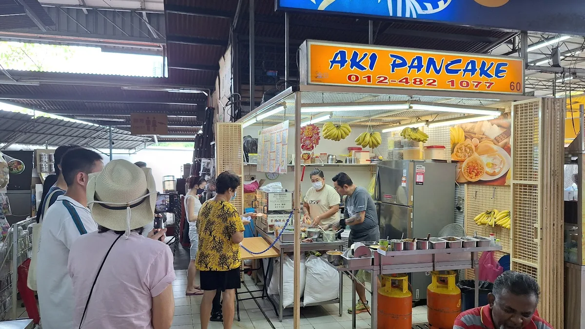 The Aki Pancake stall front inside the food centre, cooks at the griddles