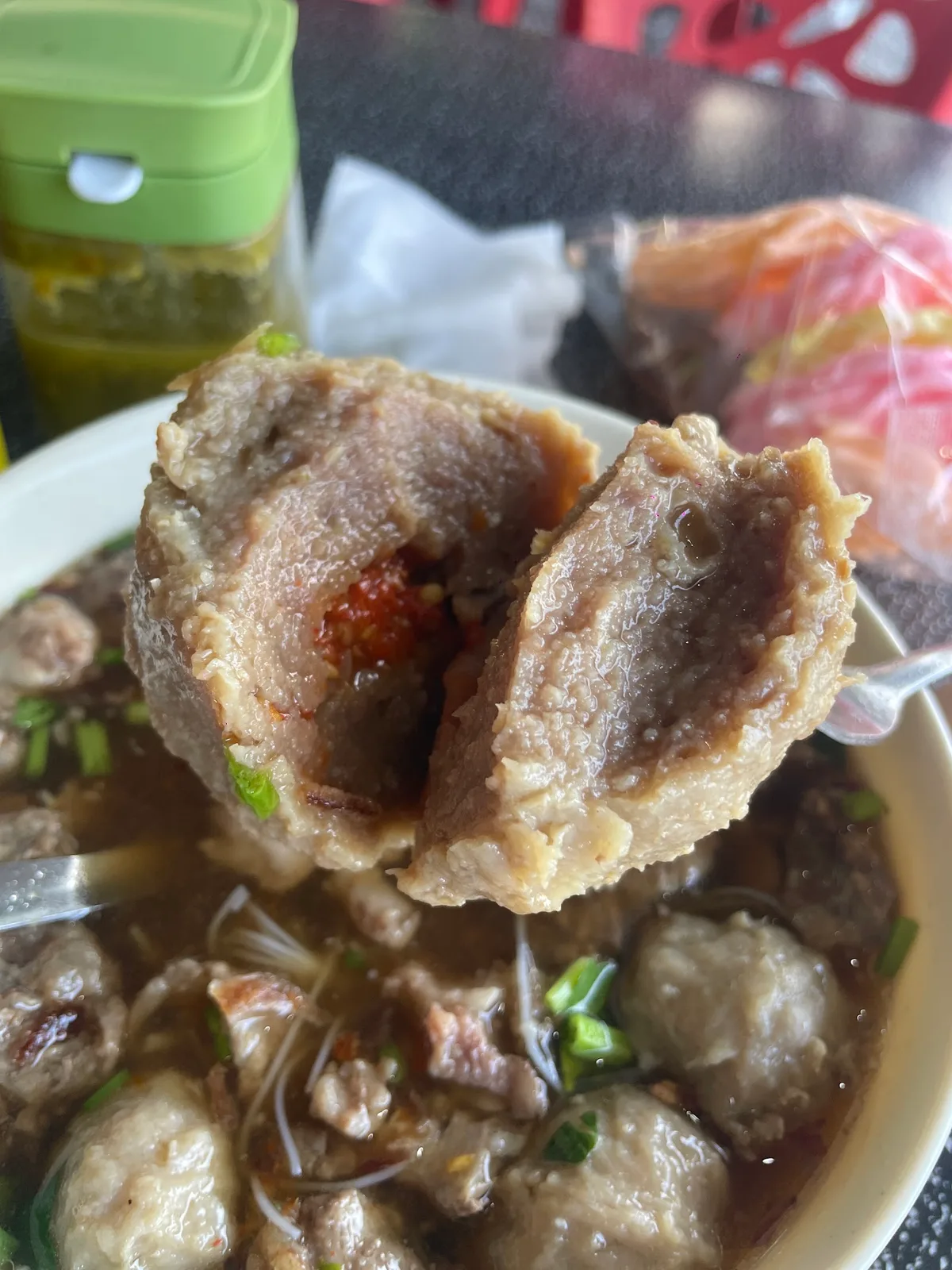Bowl of bakso with a large meatball, noodles and spring onion