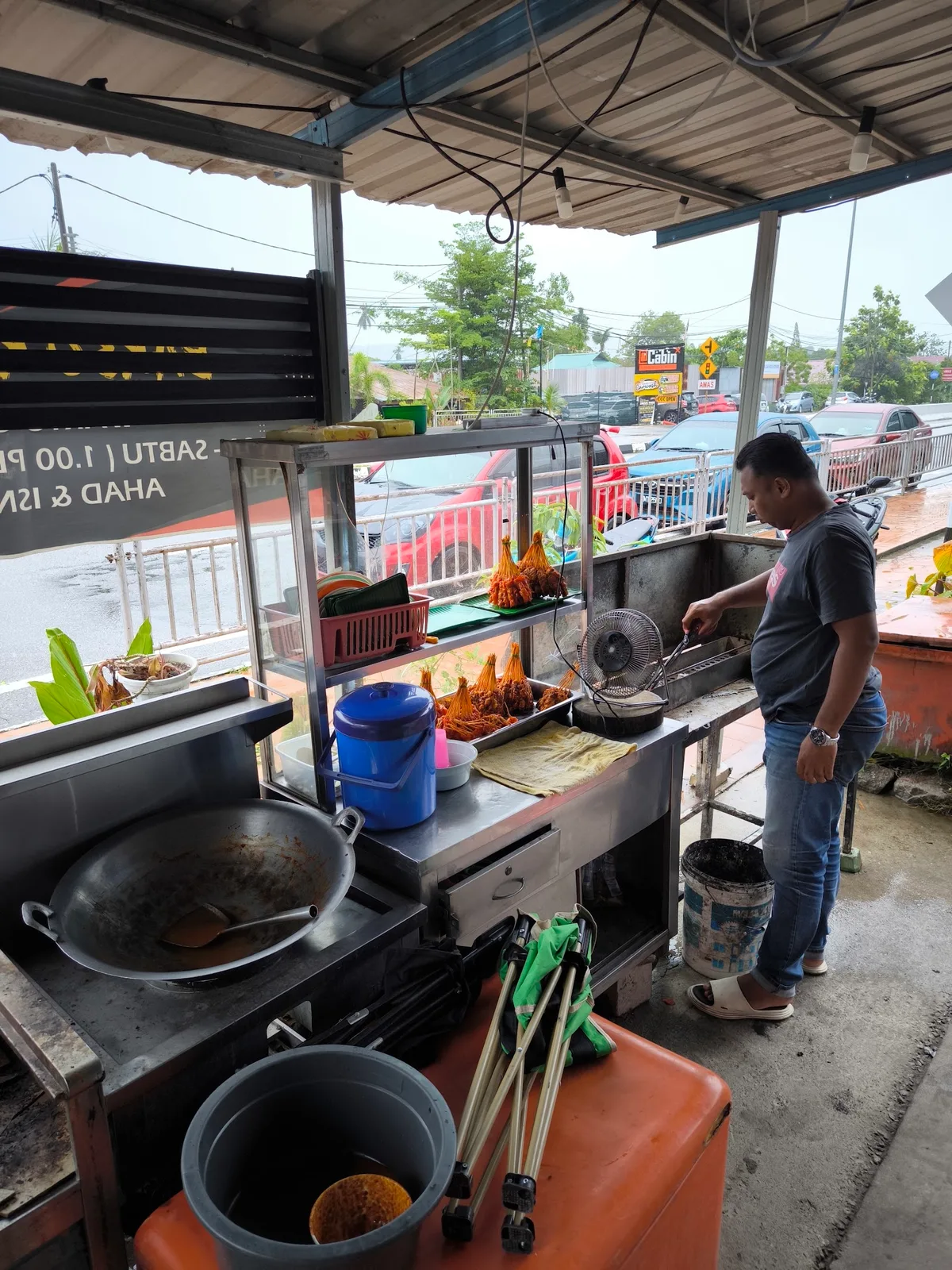 The cook working the pots behind the counter