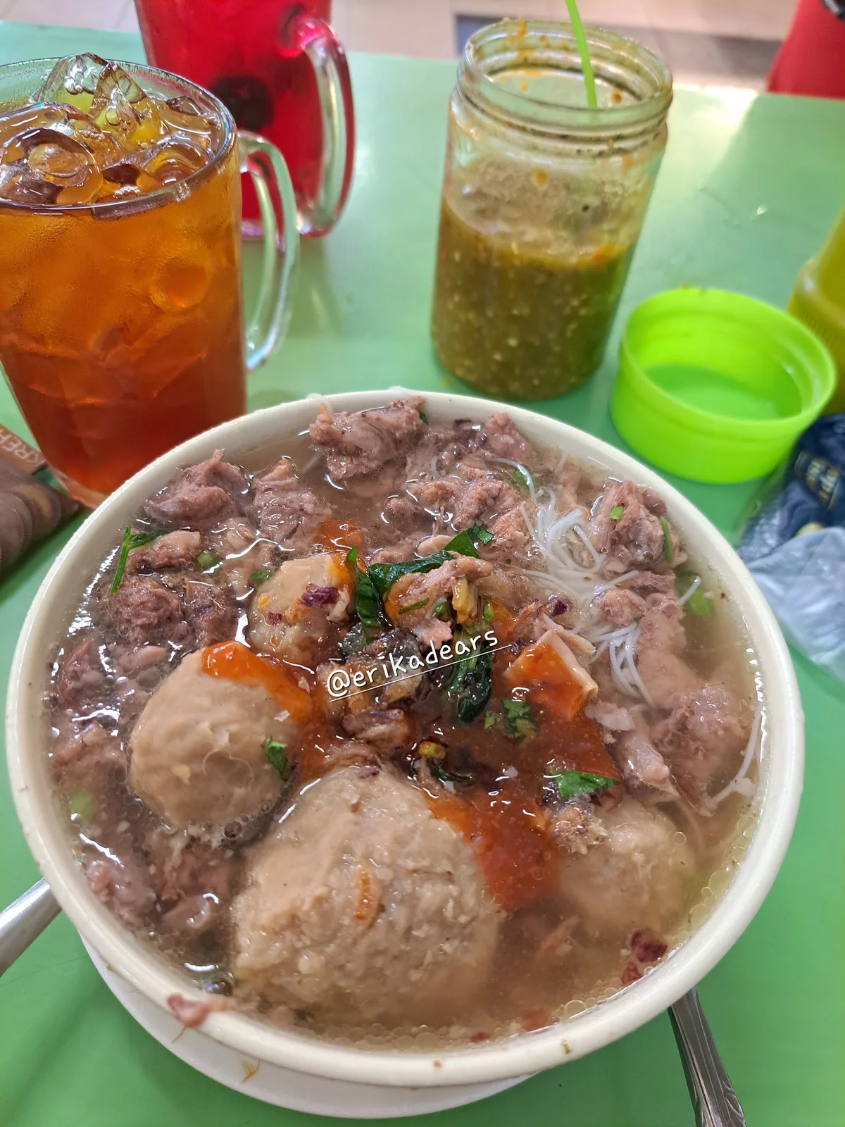 Bakso bowl with tomato and chilli beside iced drinks