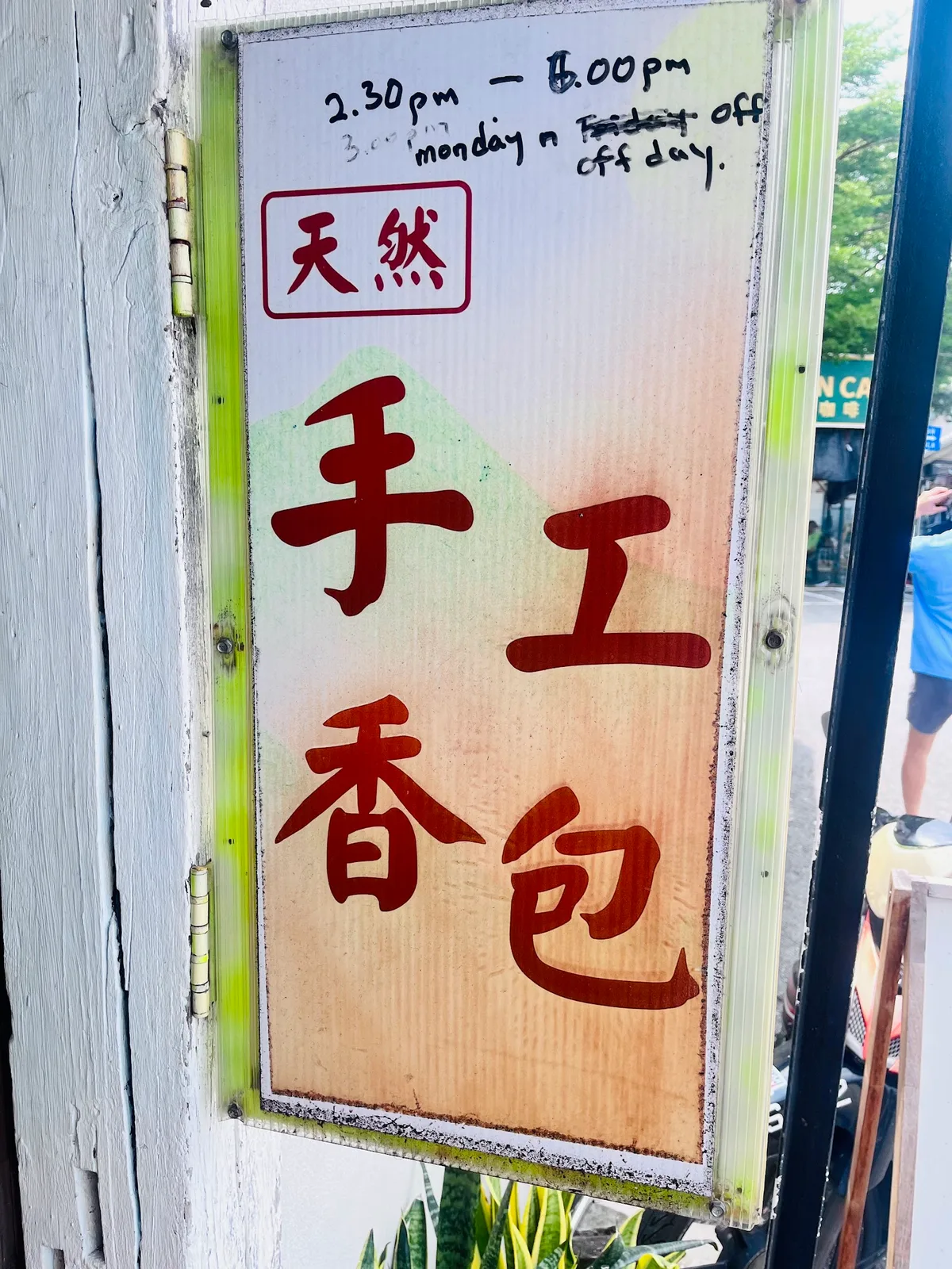 Hand-painted 手工香包 sign with opening hours