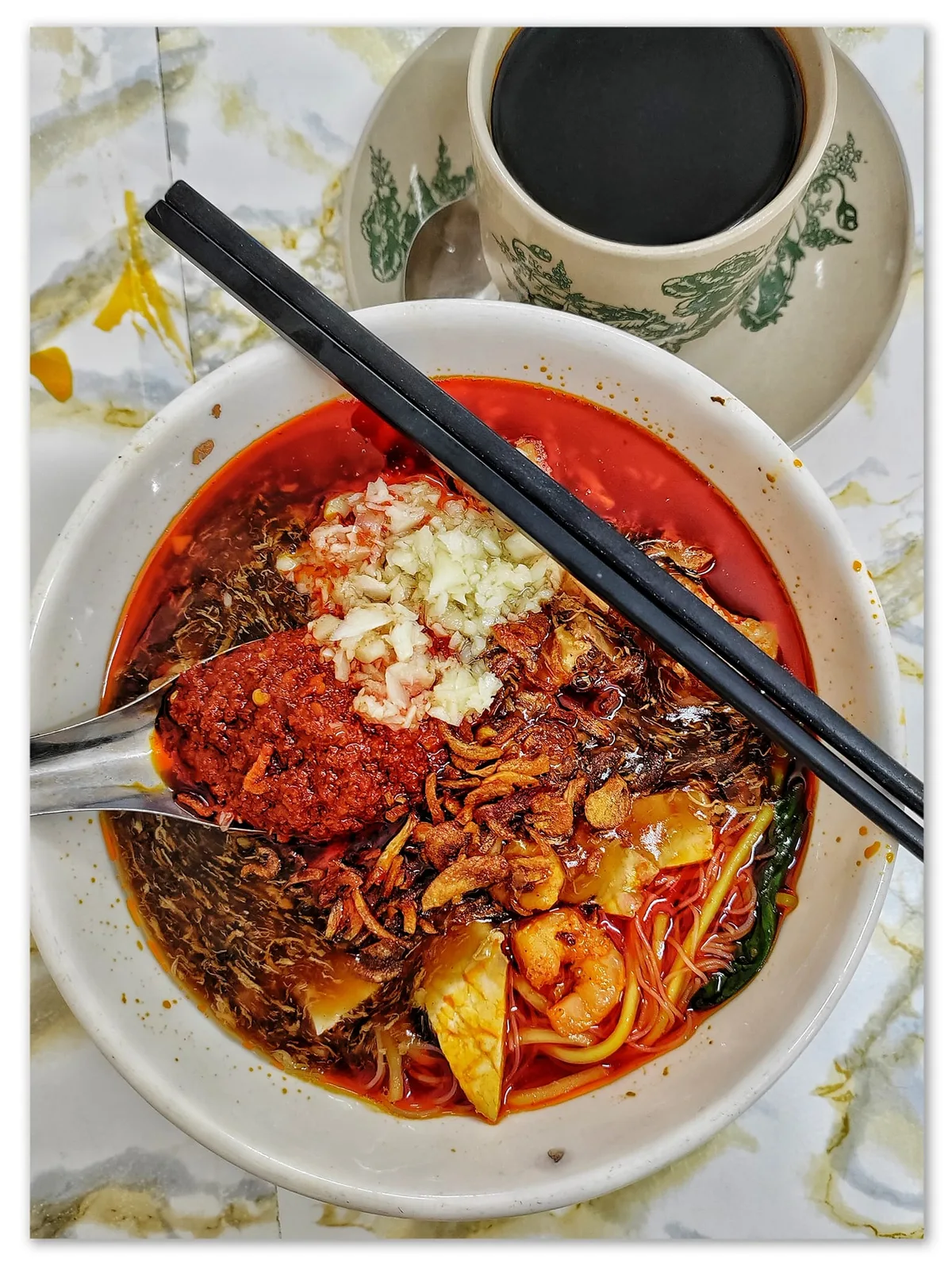 Hokkien mee with prawns, egg and sambal beside a cup of kopi