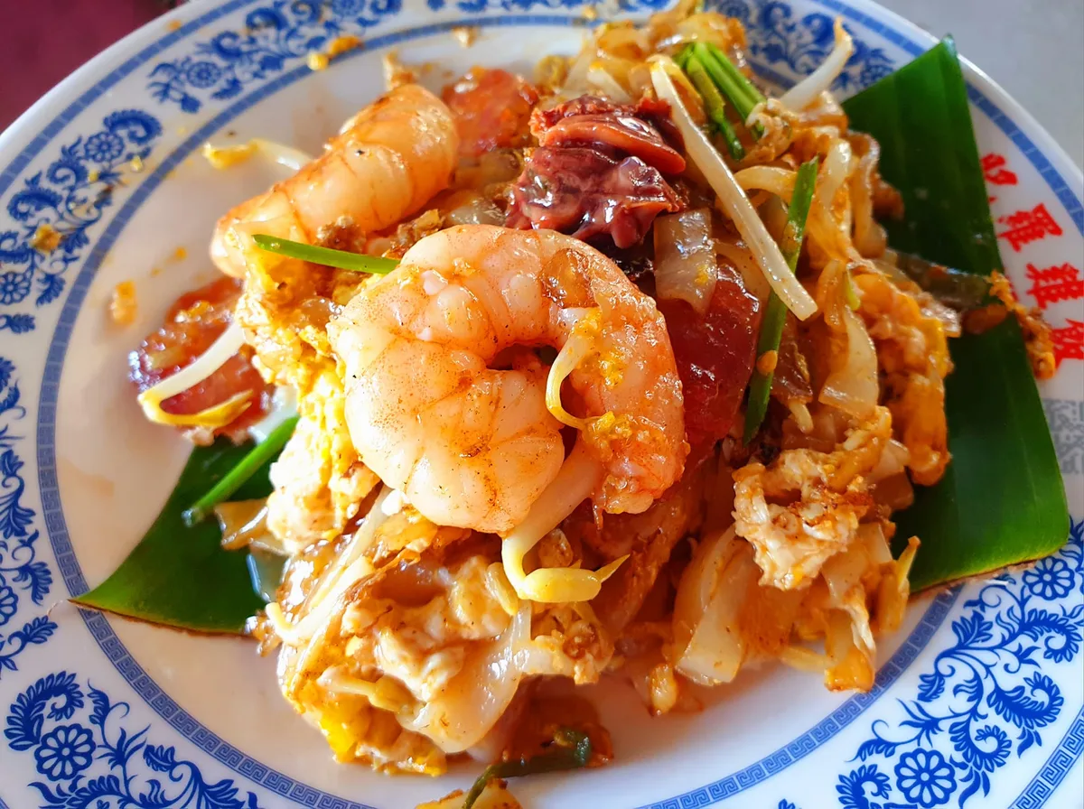 Char koay teow with big prawns on banana leaf