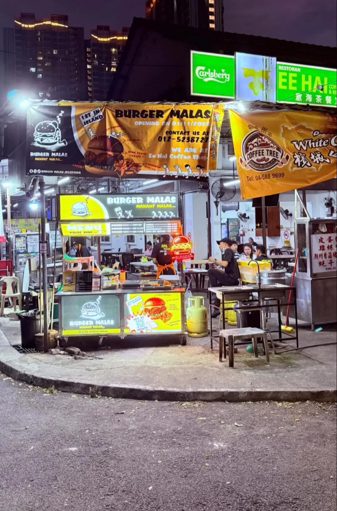 Burger Malas stall lit up at night at the coffee shop