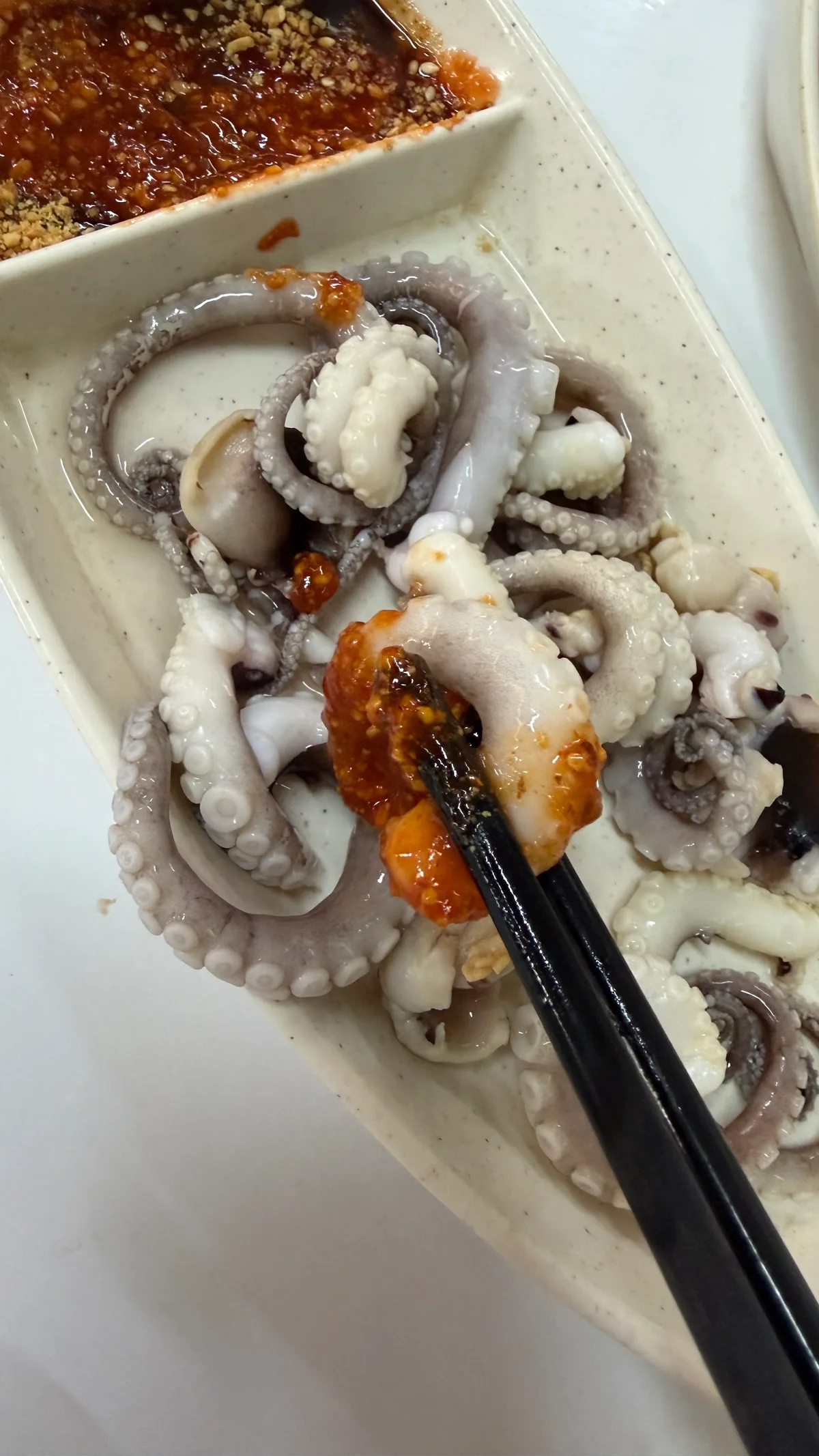 Boiled baby octopus with chili and peanut dip
