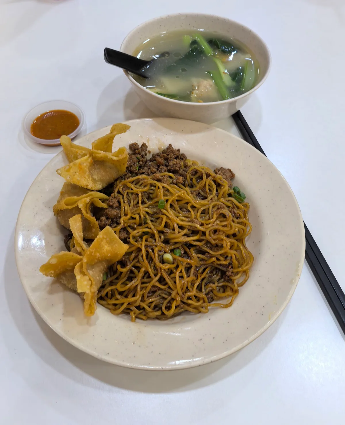 Hakka mee: dry egg noodles with minced pork and fried wanton skins, served with a bowl of clear soup