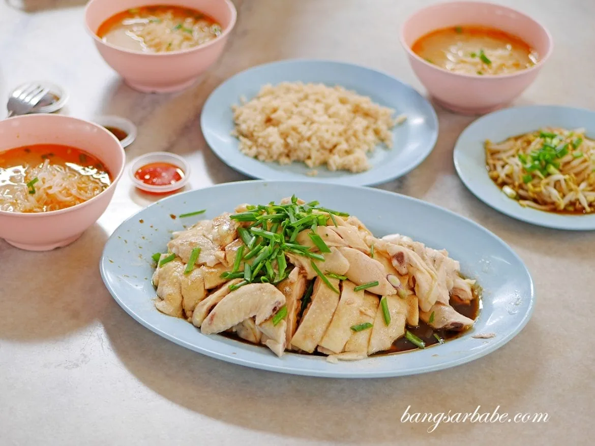 Table spread of poached chicken, chicken rice, beansprouts and two bowls of hor fun soup