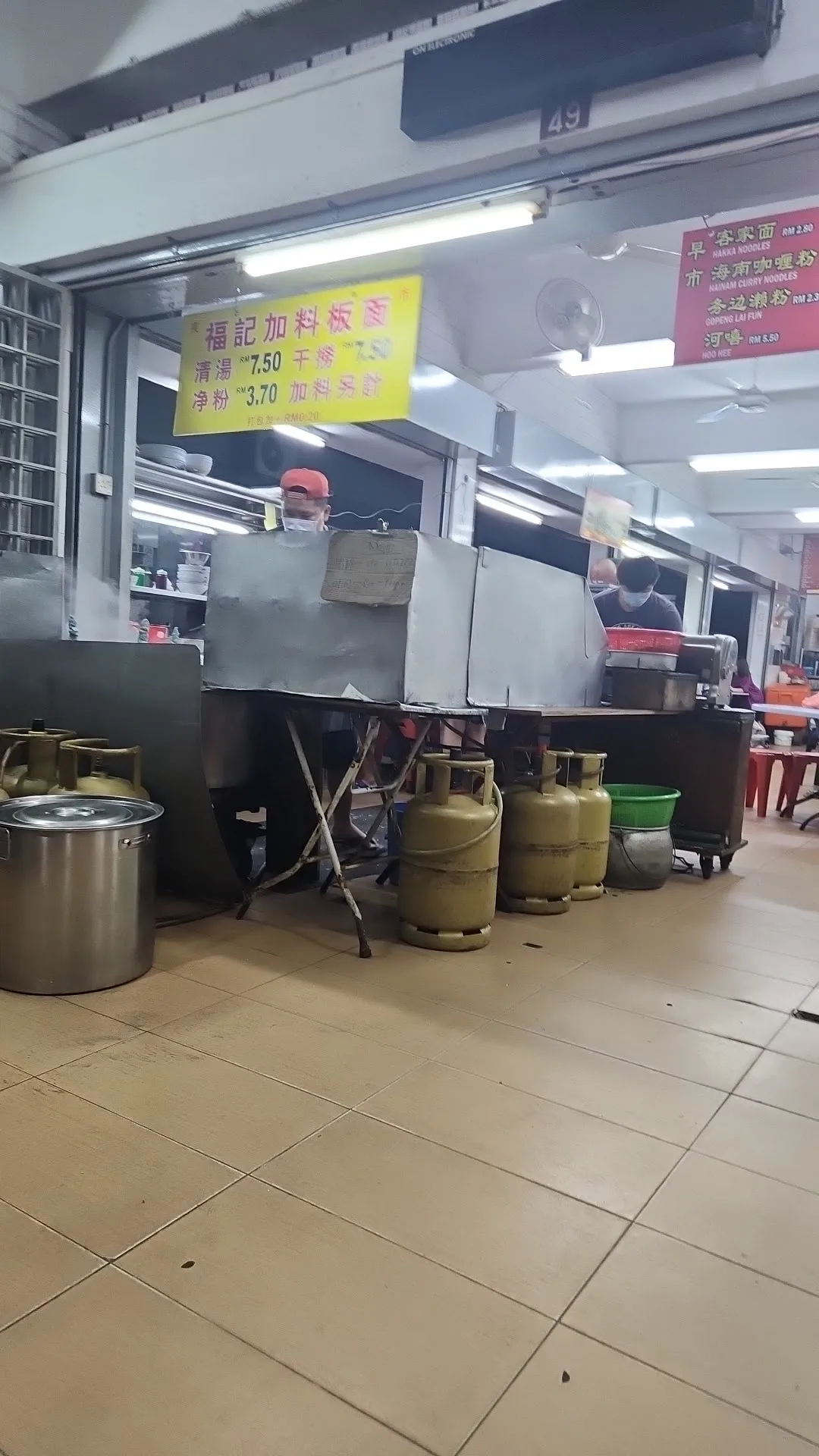 Fook Kee's yellow 福記加料板麵 signboard over the stall counter