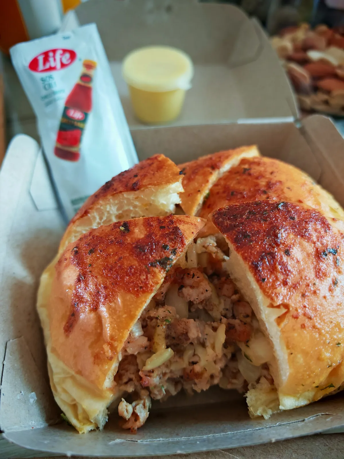Garlic cheese bun served in its box with chilli sauce