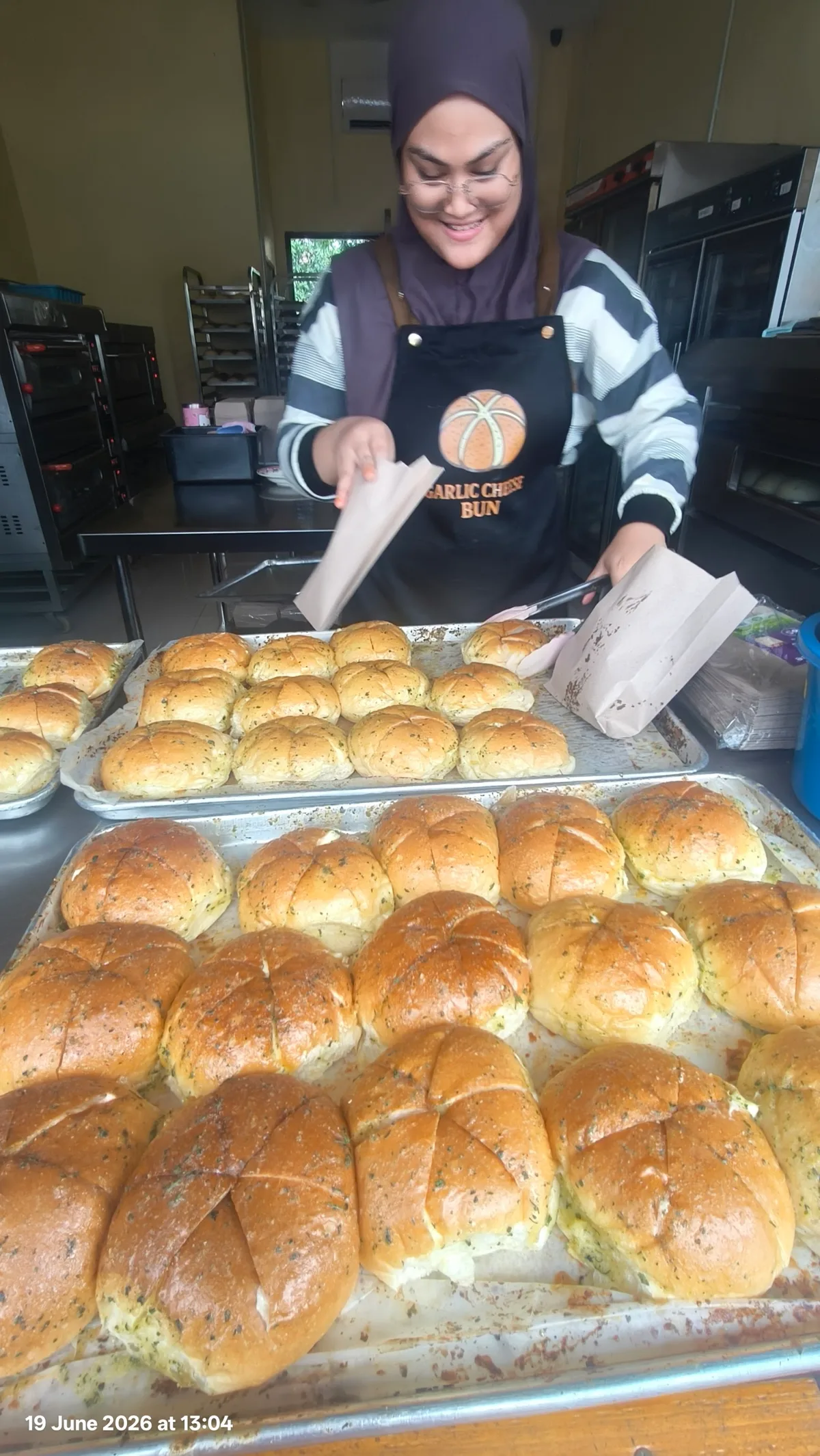 Staff bringing out a fresh tray of buns