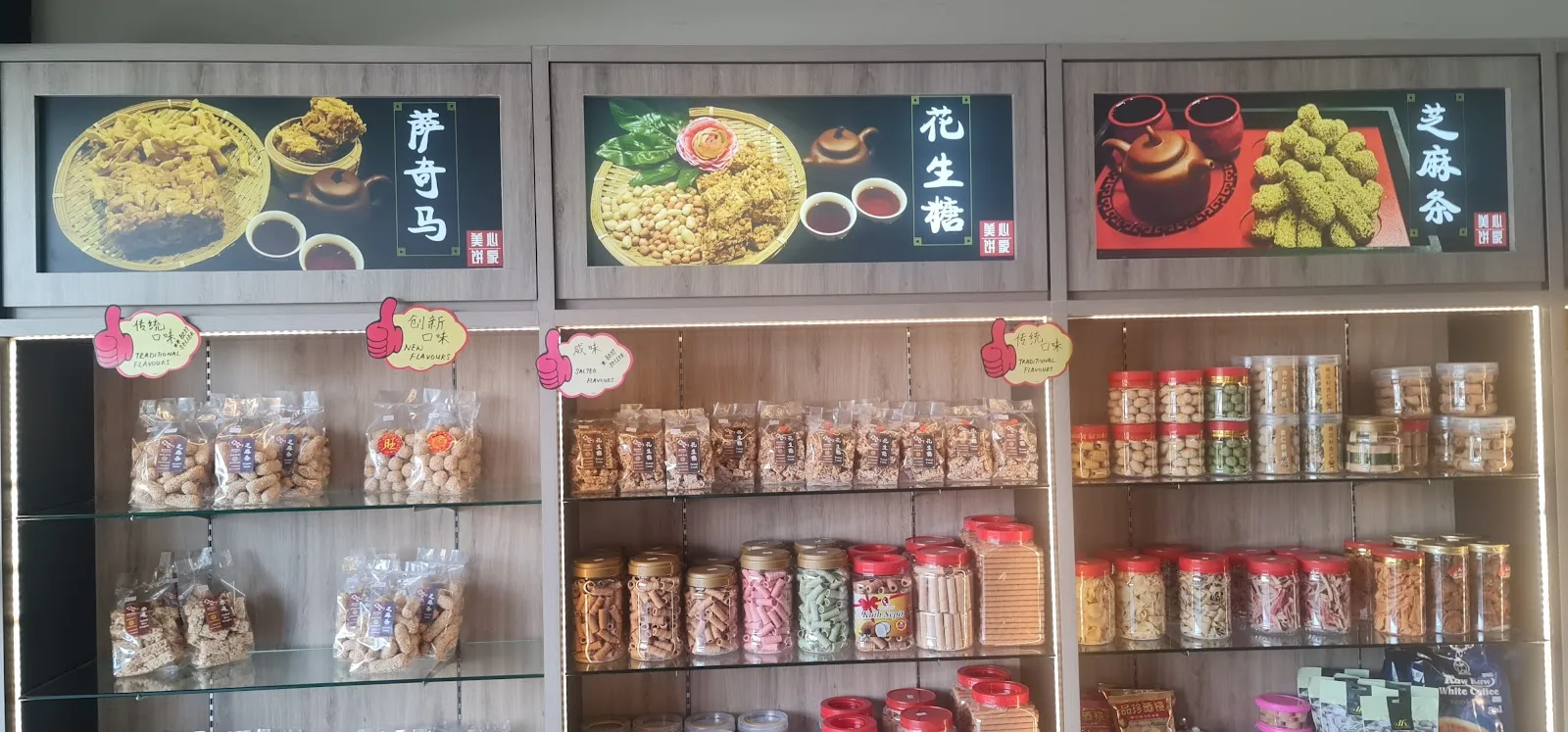 Shop shelves lined with packaged snacks and jars under lit product panels