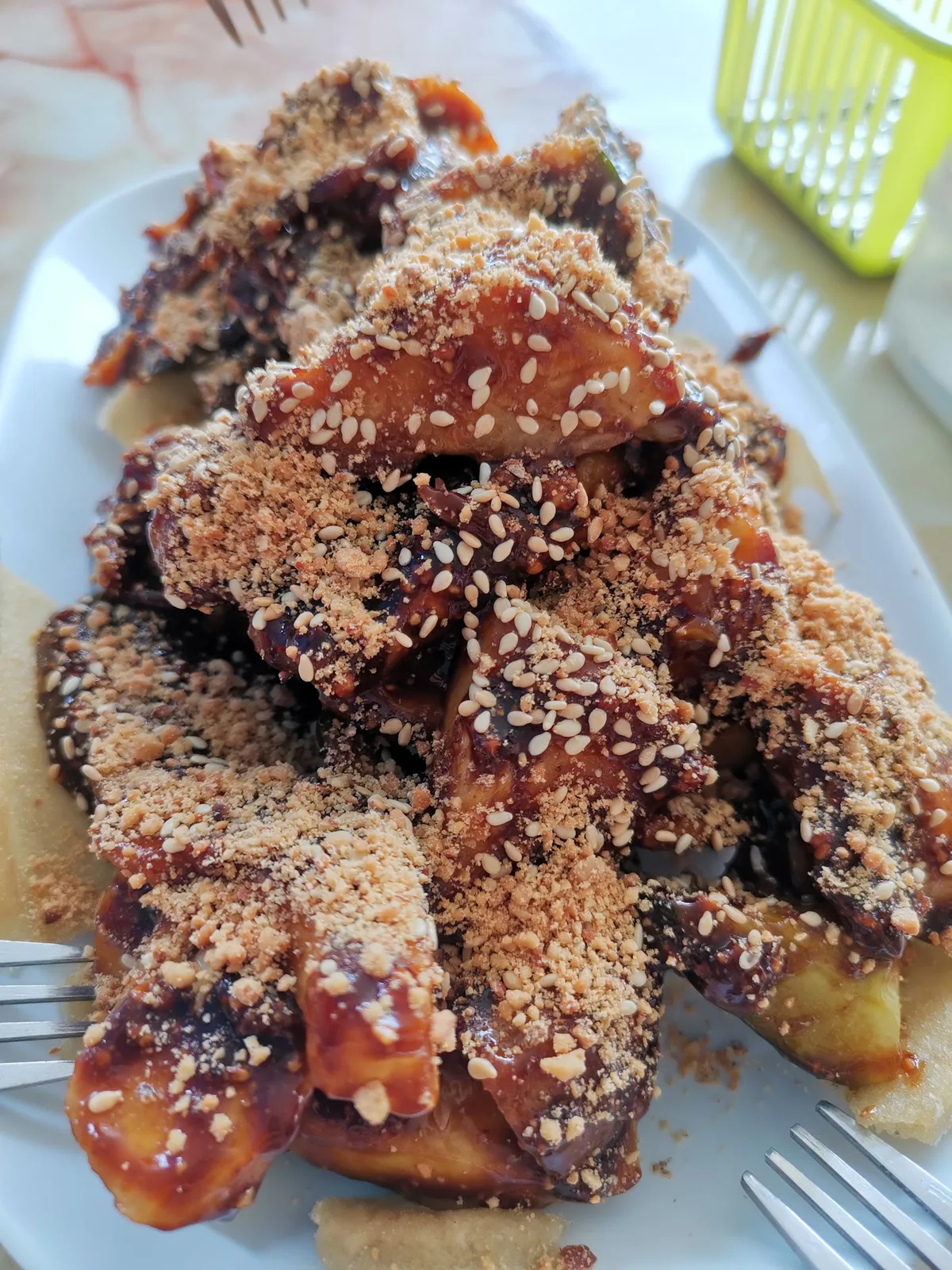 A plate of rojak in dark prawn paste, topped with crushed peanuts and sesame seeds