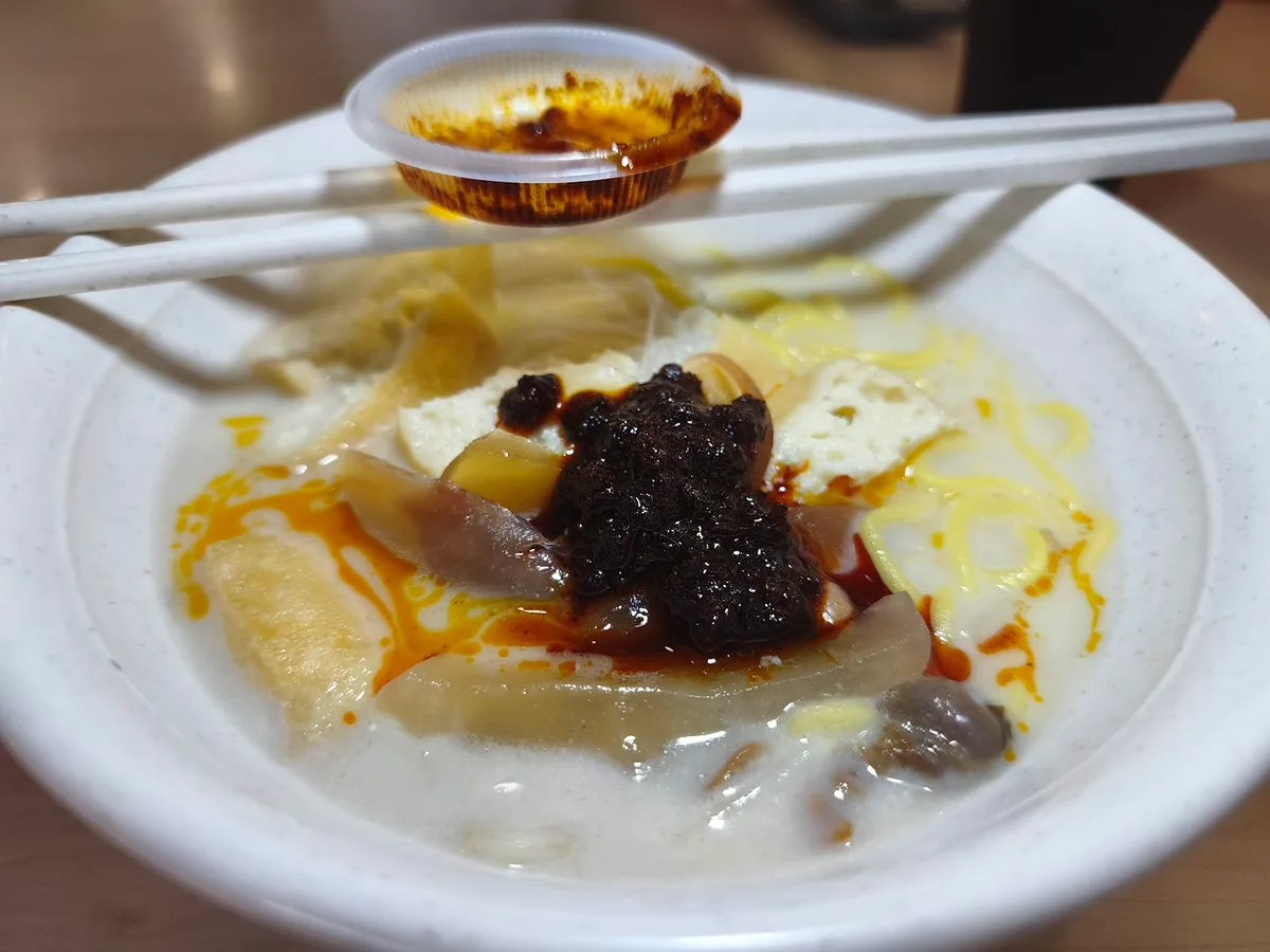 White curry mee with a spoon of chili paste on top