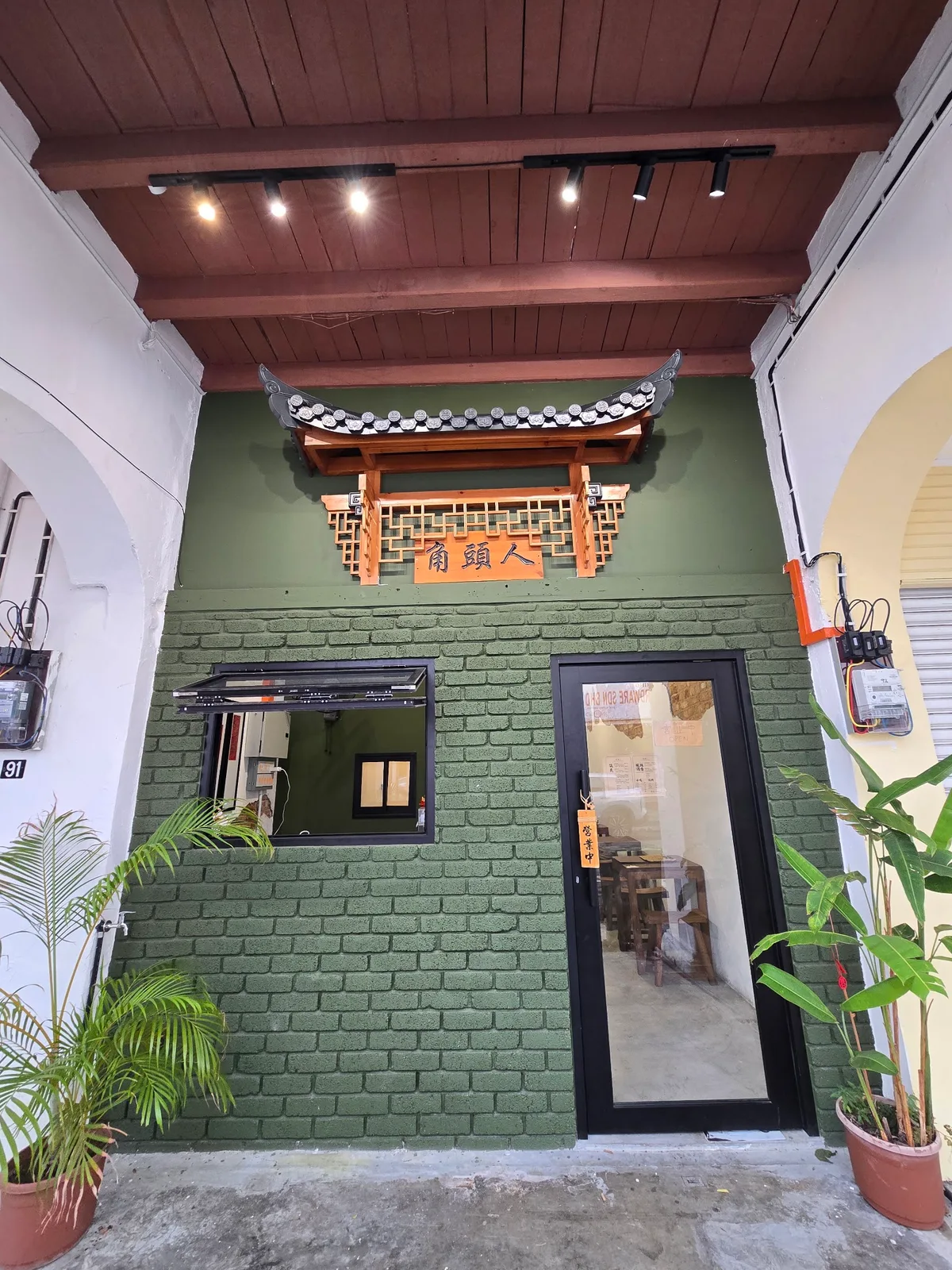 The green-brick shopfront by day