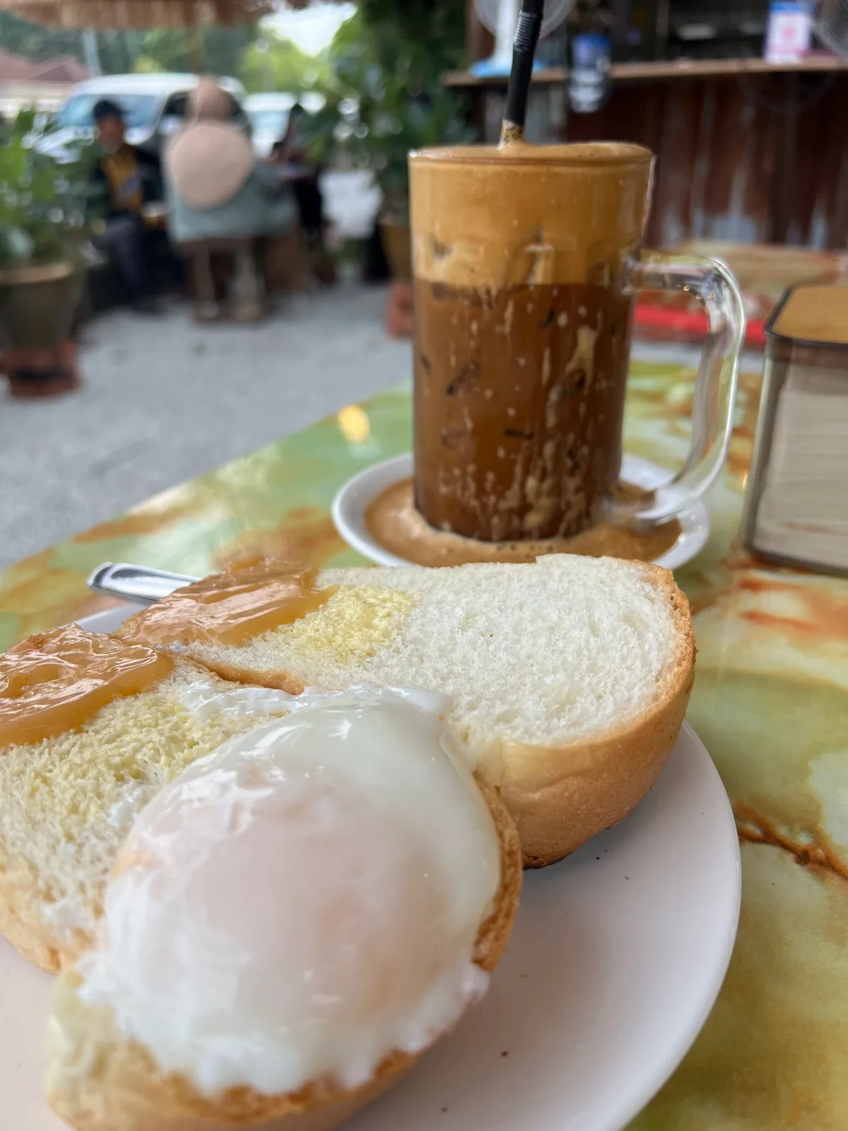 Roti bakar with half-boiled egg and iced coffee