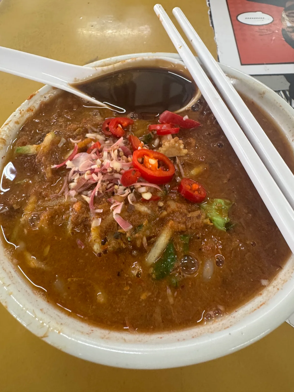 Asam laksa served on the stall's yellow formica table