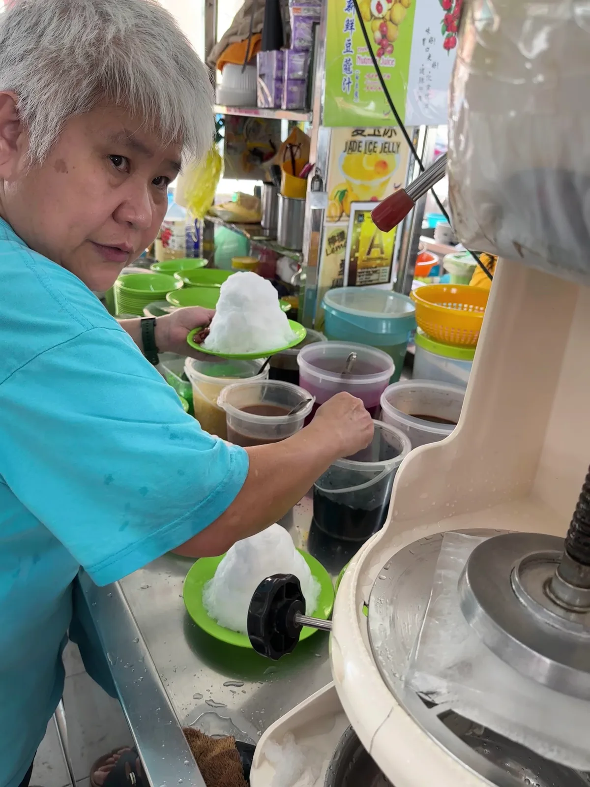 The laksa seller working behind the stall counter