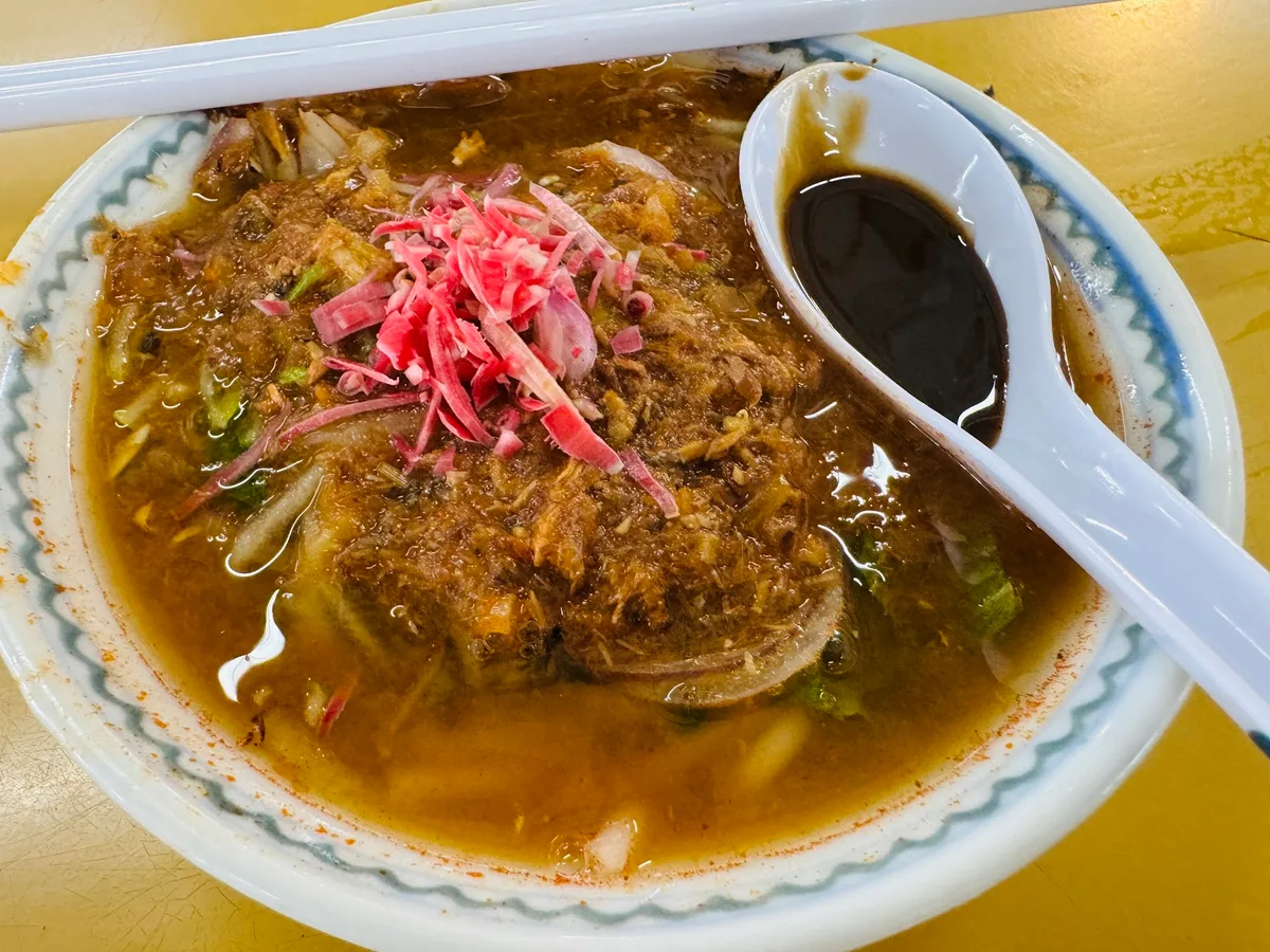 Generous bowl of laksa with a dish of hae ko alongside