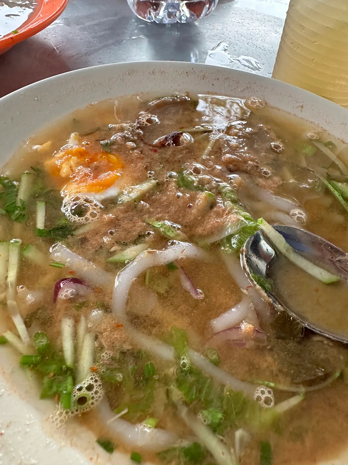 Laksa topped with flaked fish and greens