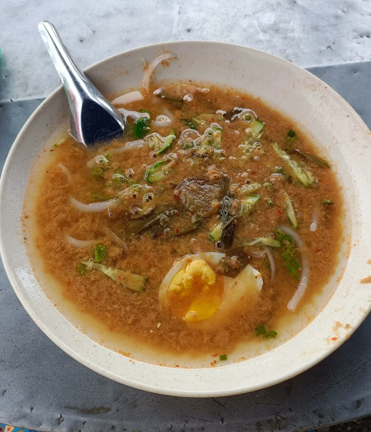 Laksa with egg in a white bowl