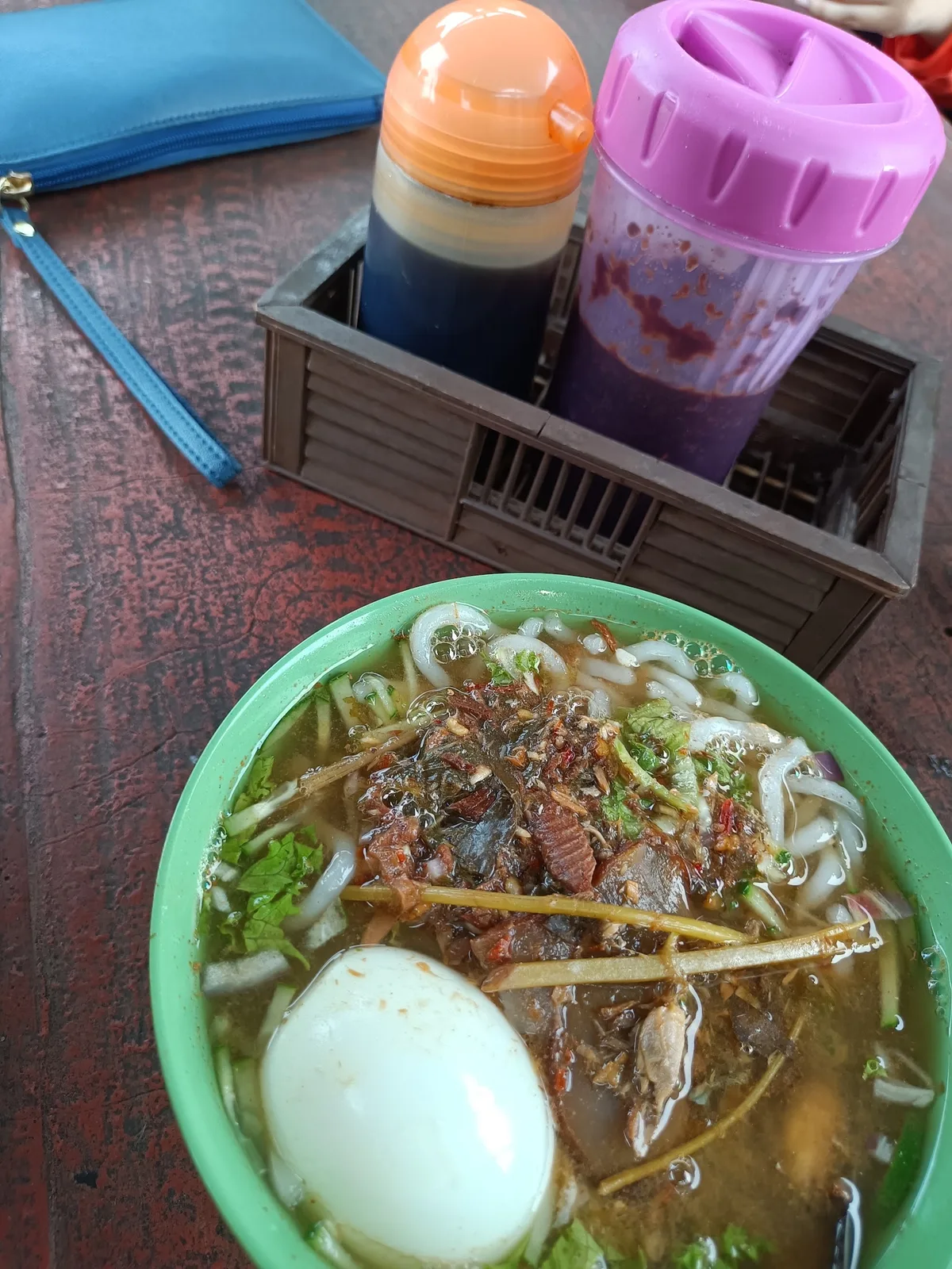 Laksa with egg, homemade soy sauce and chilli at the table