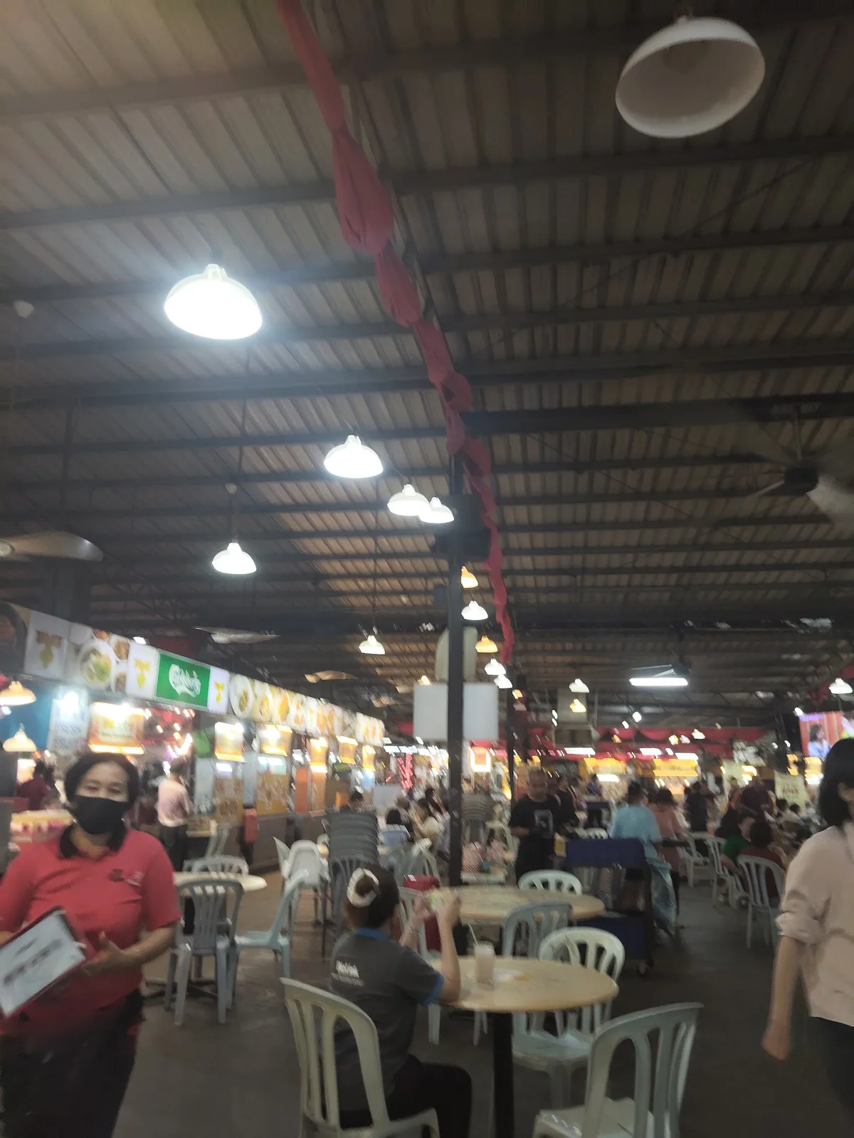 Inside the food court with rows of tables and stalls