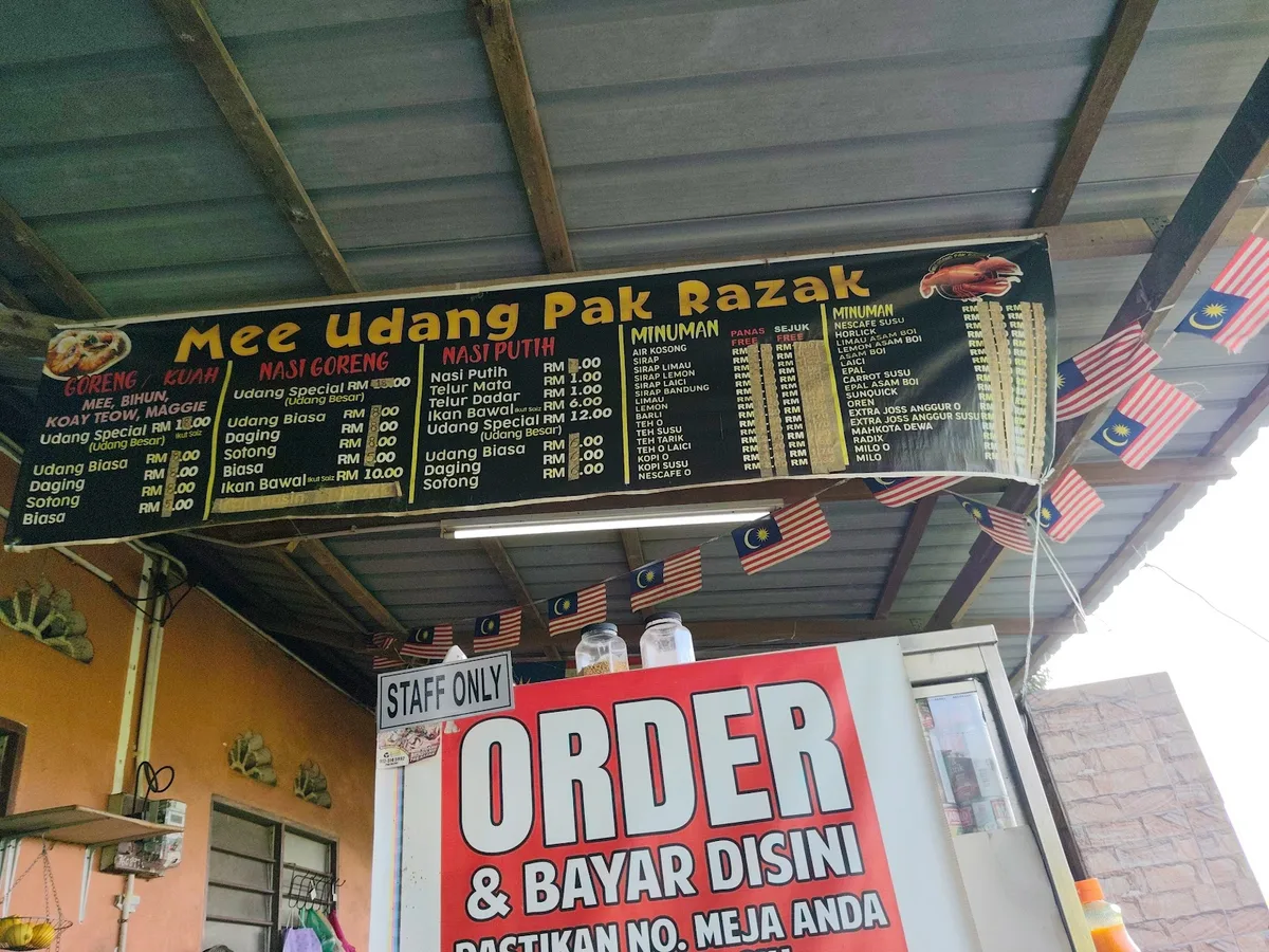 Mee Udang Pak Razak signboard and price list over the order counter