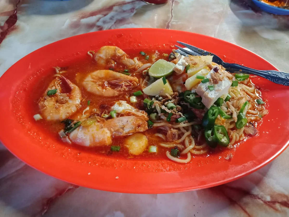 Mee udang with prawns on an orange plate