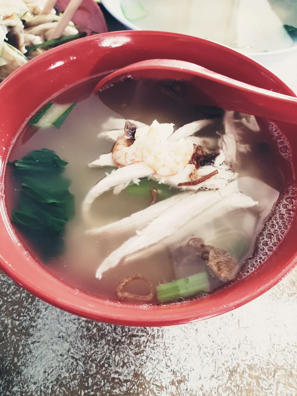 Chicken hor fun soup in a red bowl