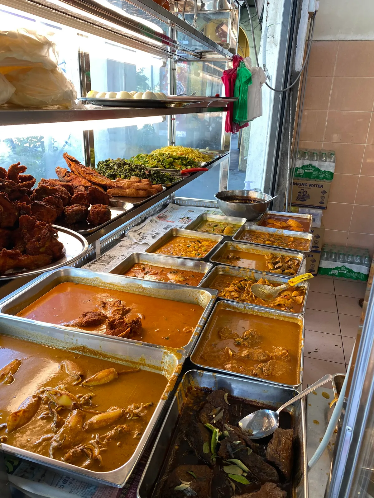 Trays of curry and lauk at the counter