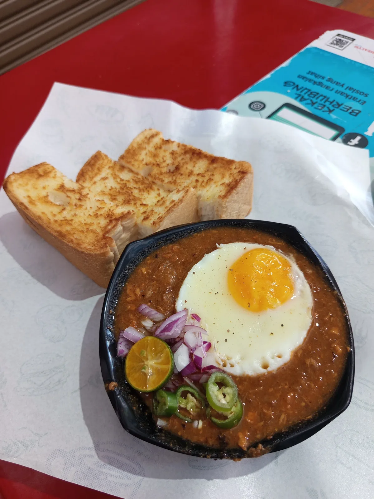 Kacang phool with fried egg, red onion, calamansi and green chilli, charred roti bakar alongside