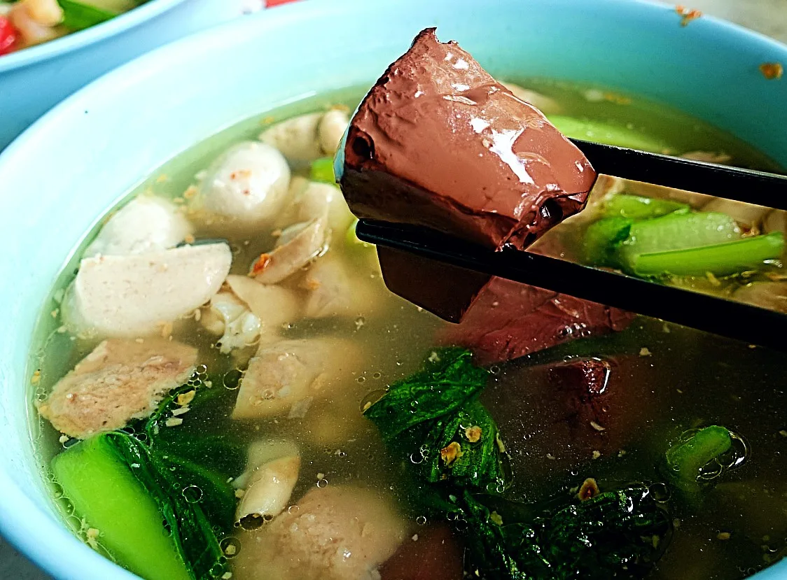 Pig blood cube lifted from a bowl of yong tau foo soup