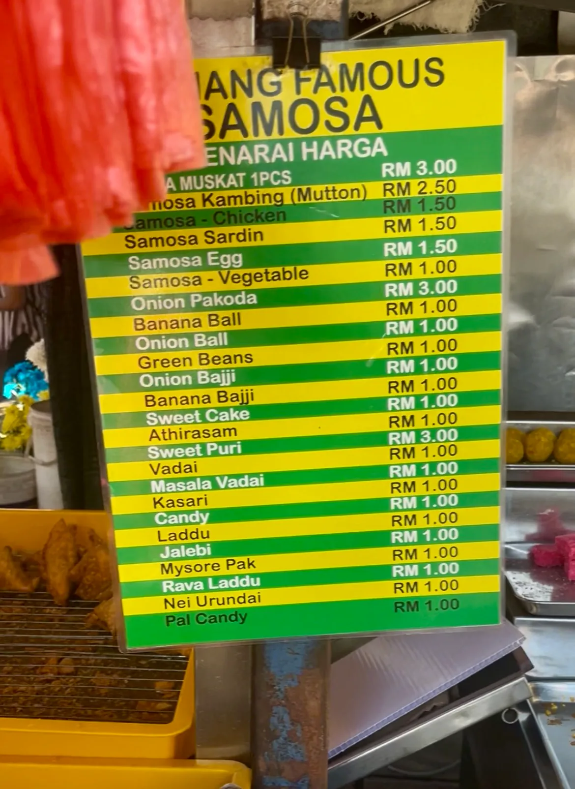 Price board listing samosas, vadai and pakora