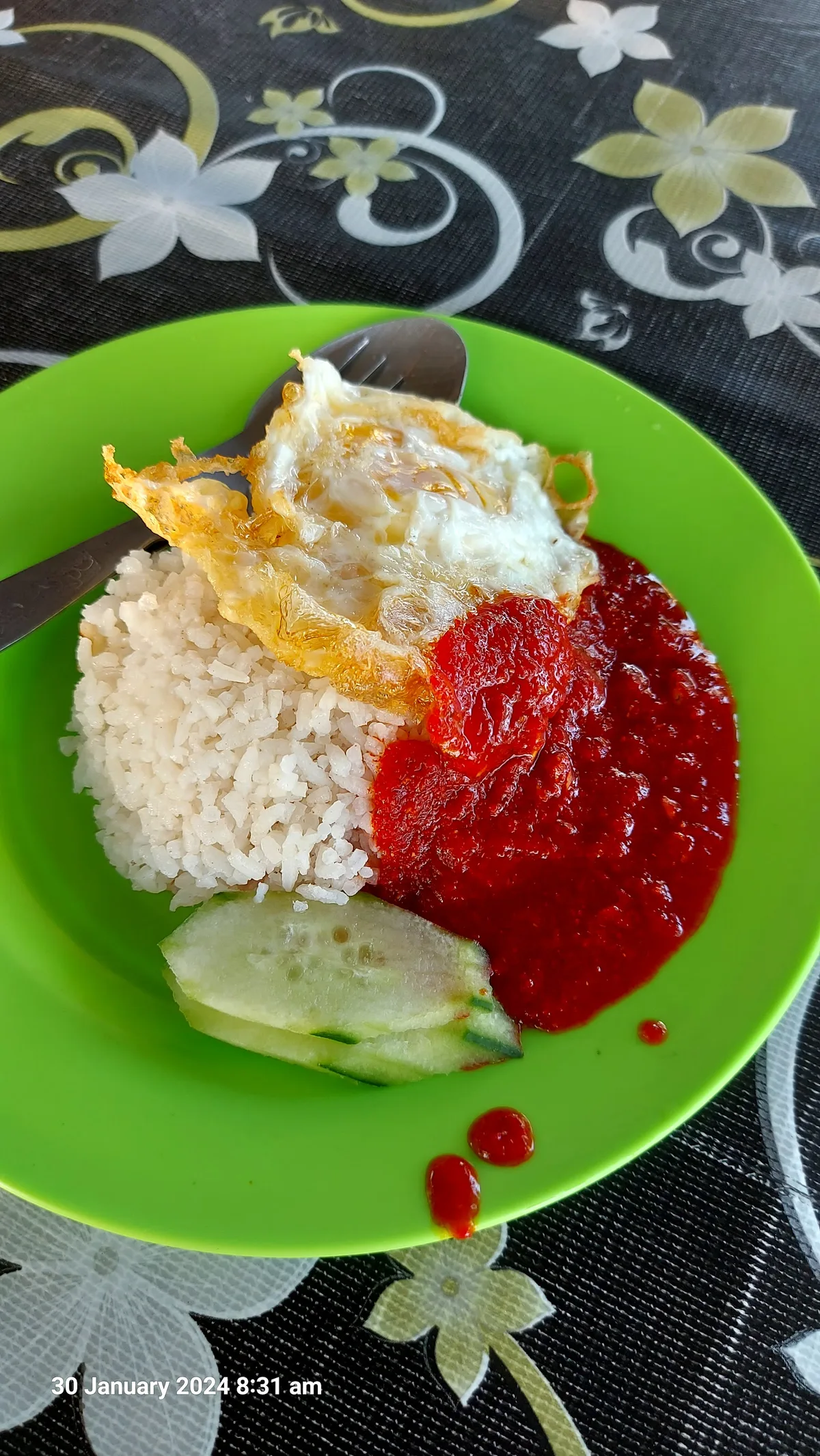 Nasi lemak with a fried egg, sambal and cucumber