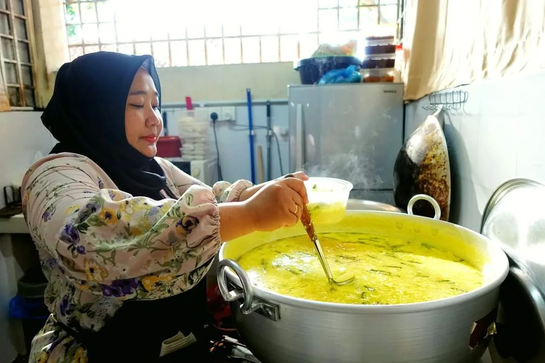 Stirring the lontong gravy