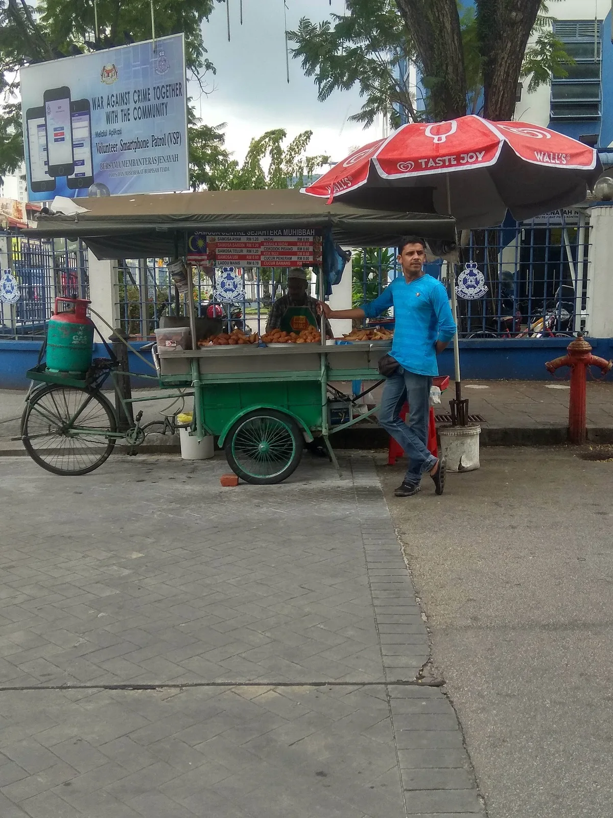 Push-cart under its umbrella by the road