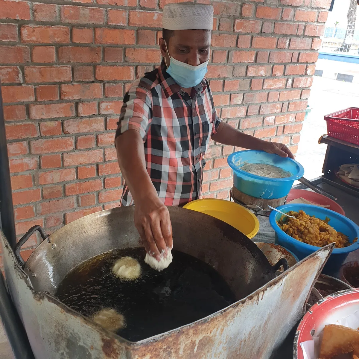 Frying samosas in the wok at the cart