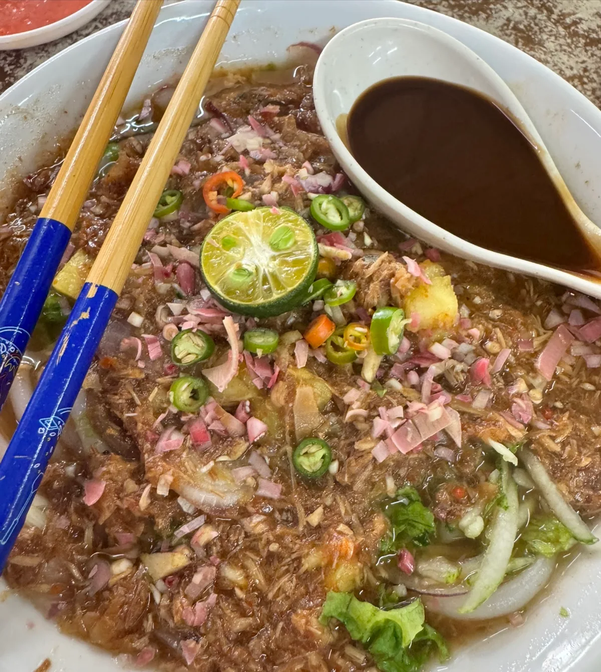 Asam laksa with shredded fish, lime, chilli, onion and mint, hae ko on the side