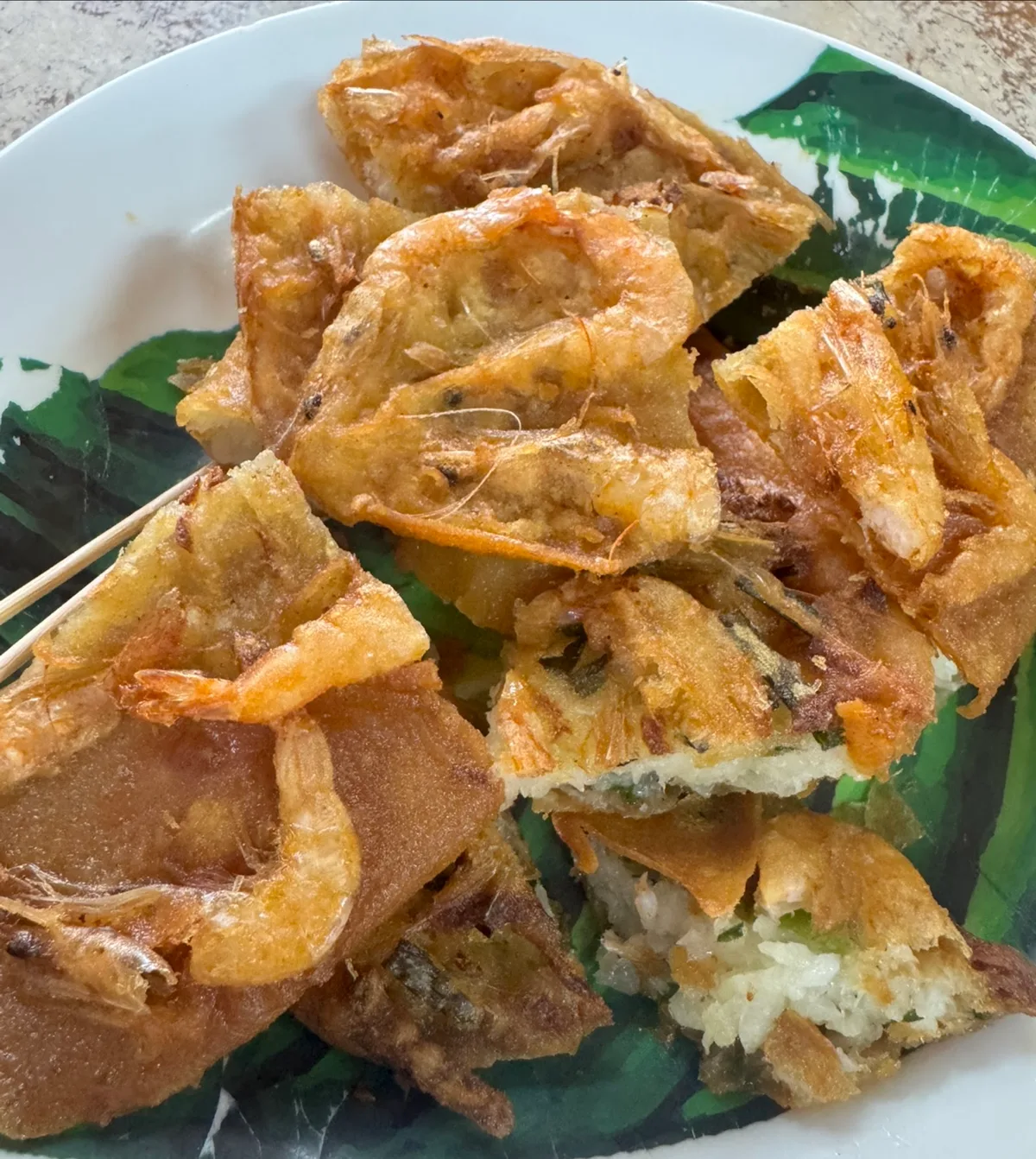 Crispy prawn fritters on a banana leaf plate