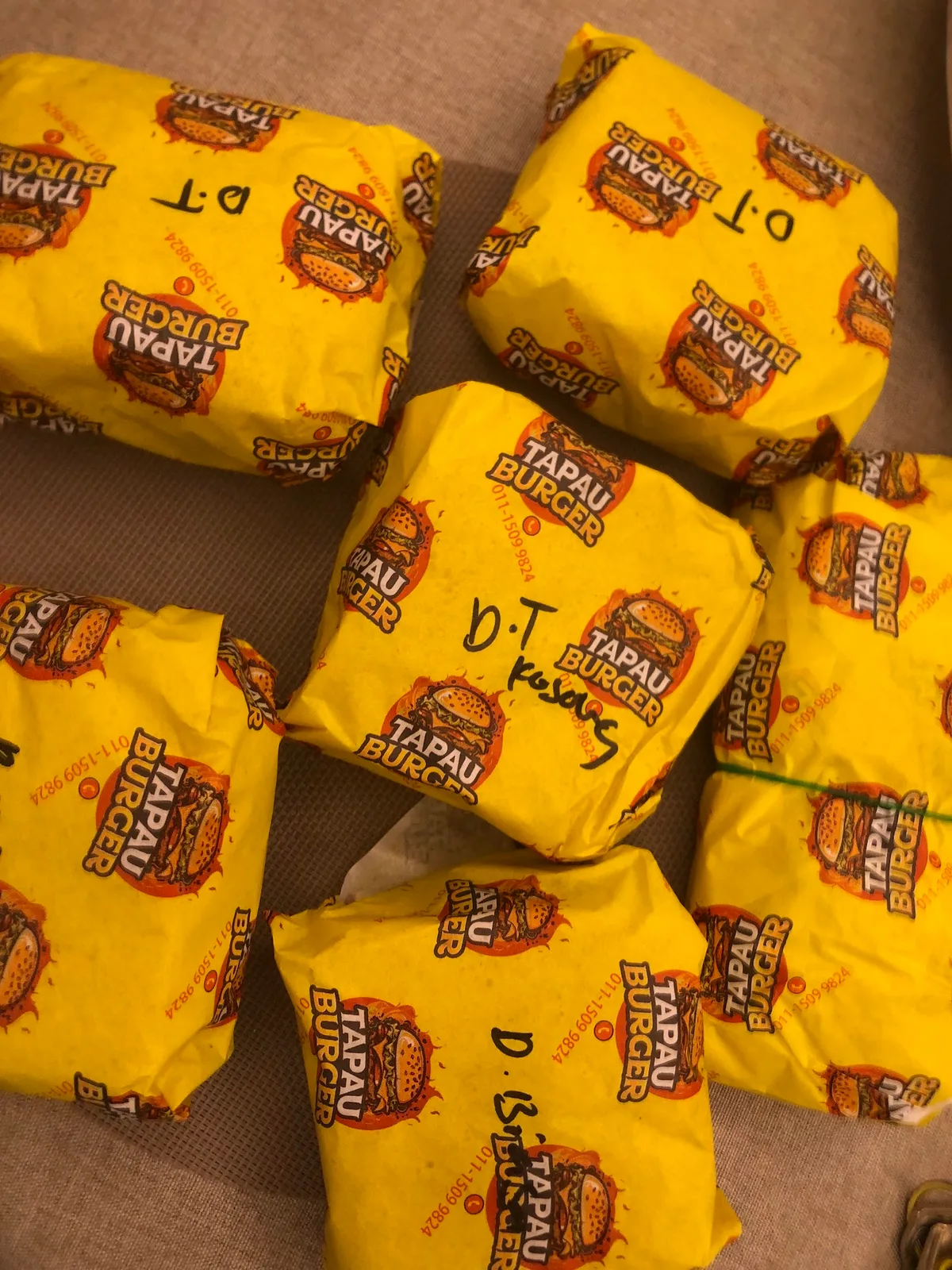 A pile of burgers in their yellow wrappers