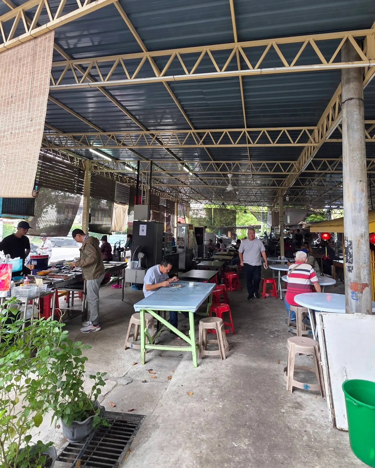 The open air Under The Tree food court on Lengkok Burma, hawker stalls down one side and diners at the tables