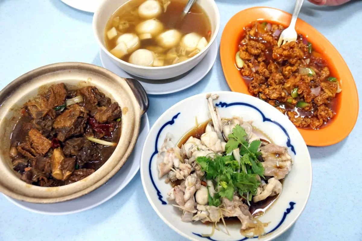 Table spread of lamb belly claypot, fish ball soup, sweet and sour fried meat and steamed frog legs